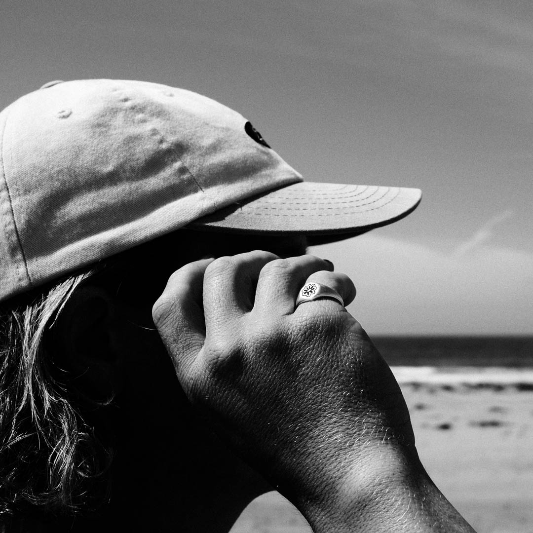 Man wearing sterling silver flower signet ring at beach